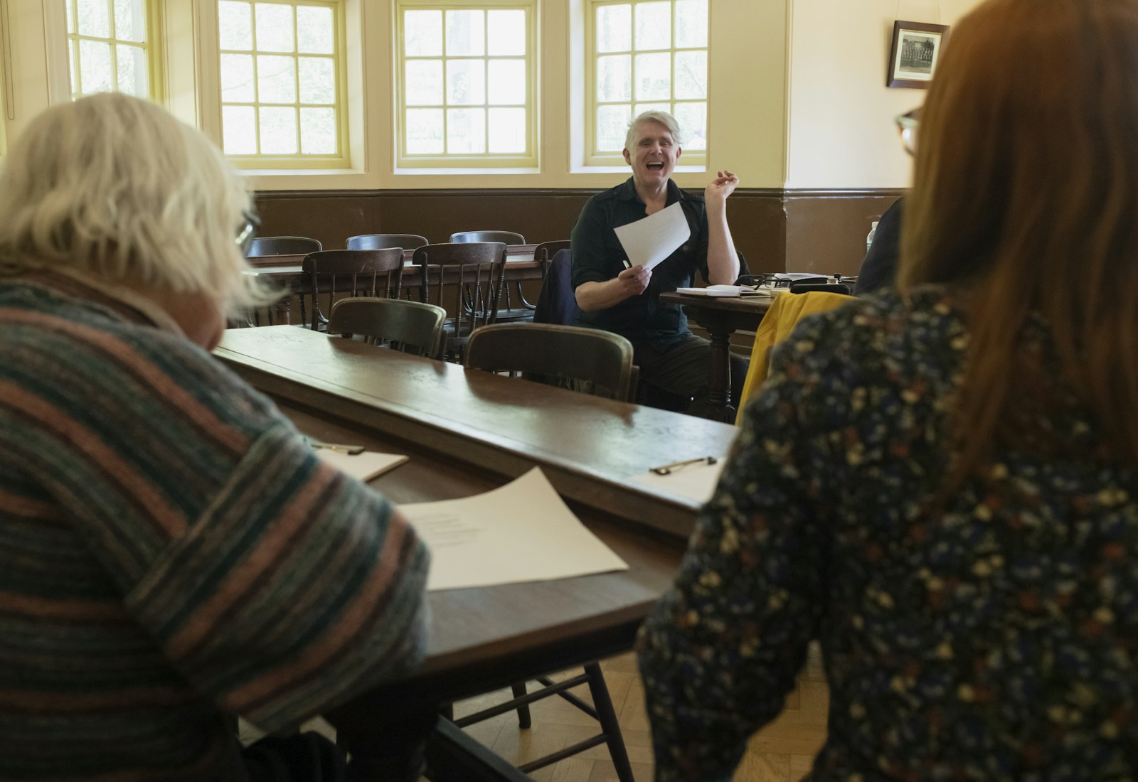 A community workshop with participants gathered around tables.
